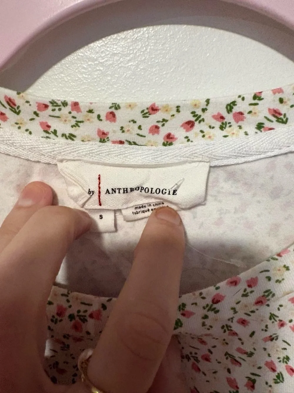 Anthropologie white cotton blouse with small pink ditzy floral print and ruffles
